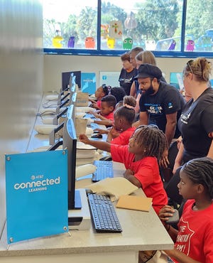 AT&T employees are shown volunteering at the company's new Connected Learning Center in West Palm Beach.  Opened in March, this is the first facility of its kind created by AT&T as part of its commitment to bridge the digital divide.