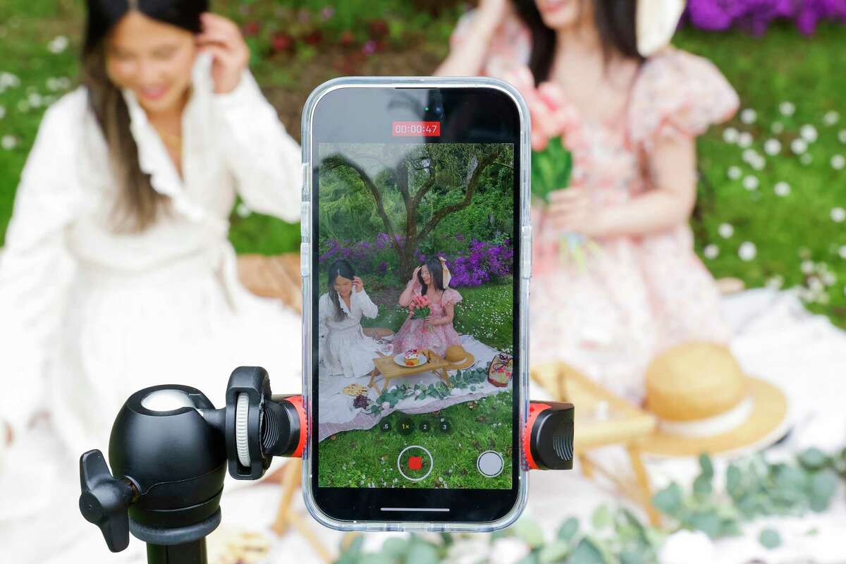 Ally Chen (left) joins her friend Cristina Viseu for her staged picnic at the San Francisco Botanical Gardens.  Viseu added 50,000 TikTok followers in the past three months for posting soft girl videos of elaborate picnics and decadent dinner parties, online content she says promotes self-care and femininity.
